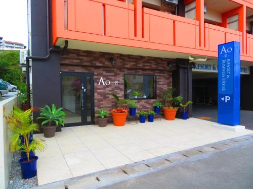 a building with potted plants in front of it at Ao Hotel in Nago