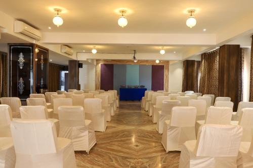 a conference room with white chairs and a stage at Regenta Central Mewargarh, Near Biological park in Udaipur