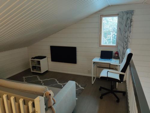 ein Schlafzimmer mit einem Schreibtisch und einem Computer in einem Zimmer in der Unterkunft Tähtisara in Syöte