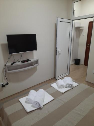 a room with two towels and a flat screen tv at Apartman Karadjordje 2 in Belgrade