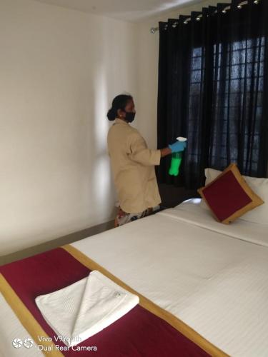 a person standing in a room looking out the window at Miles Inn Hotel in Hassan