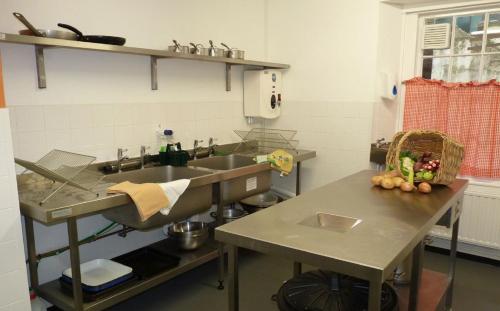 a kitchen with a sink and a counter with a table at Dulverton Hostel in Dulverton