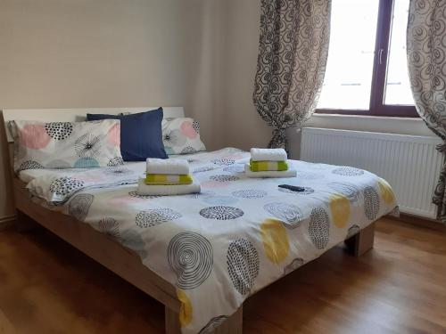 a bedroom with a bed with a white and yellow comforter at Apartament Cristina cu doua dormitoare & balcon & parcare in Onești