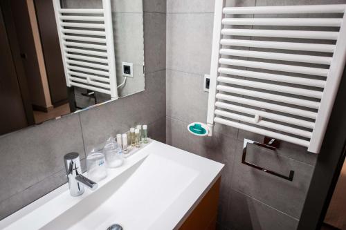 a bathroom with a sink and a mirror at WinTuWin Apartments in Rialp