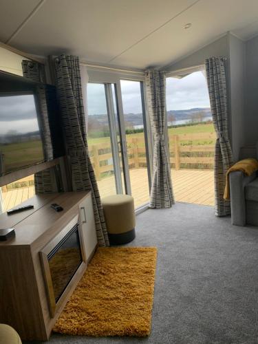 a living room with a tv and a large window at The Castleton in Dunoon
