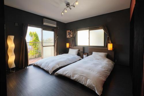 Un dormitorio con dos camas y una ventana. en Awaji Aquamarine Resort #1 BBQ OK! - Self Check-In Only, en Akashi