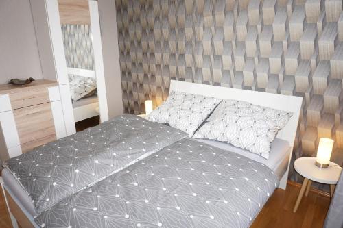 - une chambre avec un lit doté d'une tête de lit grise dans l'établissement Weindl's Ferienwohnung, à Naila