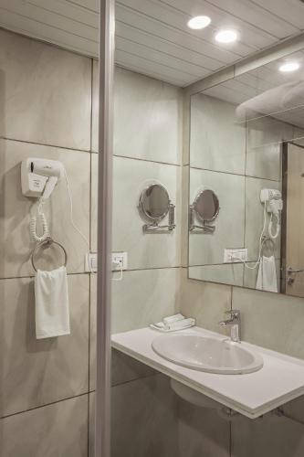 a bathroom with a sink and a mirror at Regenta Central Somnath, Bhalpara in Somnath