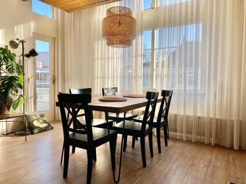 een eettafel met stoelen en een kroonluchter bij Apartment Kerkplein 7A in Zandvoort