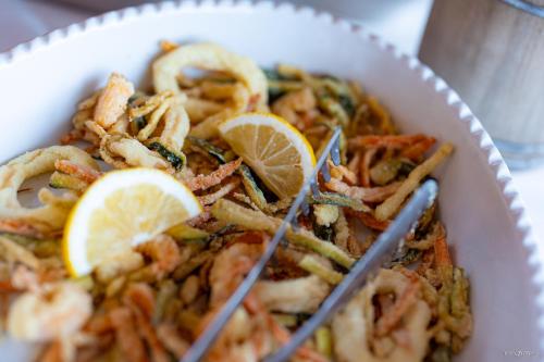 a bowl of food with shrimp with lemon slices at Hotel Belmont & Spa in Sinaia