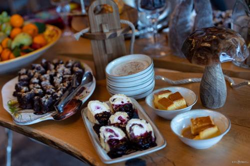 a table topped with trays of pastries and desserts at Hotel Belmont & Spa in Sinaia