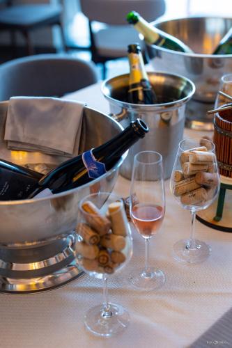 a table with two glasses of wine and a bucket of wine bottles at Hotel Belmont & Spa in Sinaia