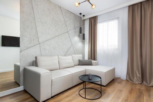 a living room with a white couch and a table at Moduo Apartments Warsaw by Renters Prestige in Warsaw