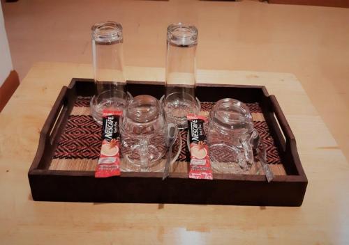 a tray with four empty wine glasses on a table at Nut Mansion Suvarnabhumi in Bang Phli