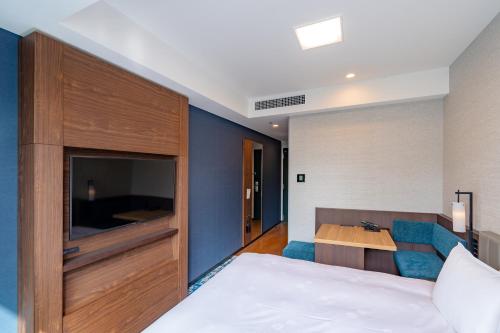 a hotel room with a bed and a desk at The Royal Park Canvas - Kobe Sannomiya in Kobe