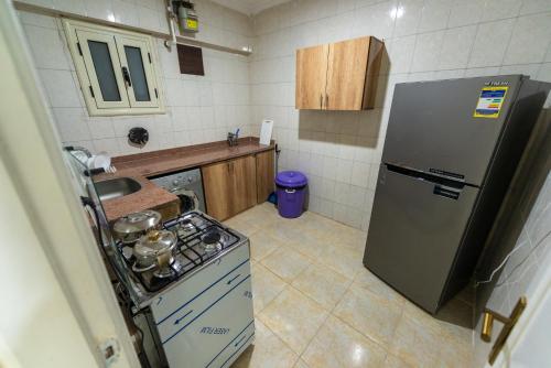 a small kitchen with a refrigerator and a stove at ZAFERO POREFAG- Families only in Alexandria