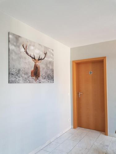 a painting of a deer on a wall next to a door at ARRIVEL Pension Pliening - bisher Novitel in Pliening