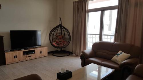 a living room with a couch and a flat screen tv at Shimmer B&B in Magong