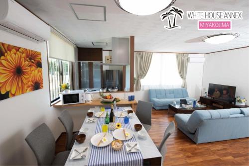 a kitchen and living room with a table and chairs at Miyakojima White House Annex in Miyako-jima