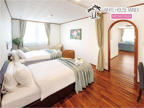 2 Betten in einem Zimmer mit einem weißen Gasthof in der Unterkunft Miyakojima White House Annex in Miyako-jima