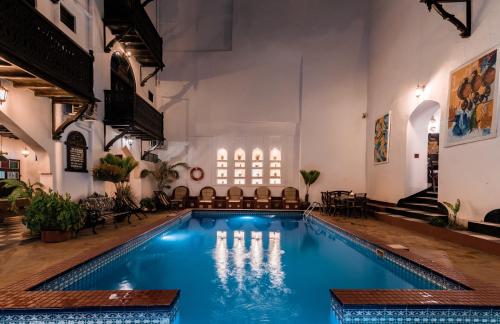 a swimming pool in a building with a church at Dhow Palace Hotel in Zanzibar City
