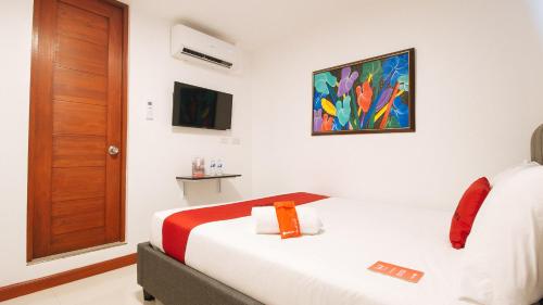 a hotel room with a bed and a painting on the wall at RedDoorz Plus @ Costa Roca Balamban in Cebu City