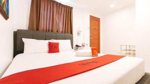 a bedroom with a large white bed with red pillows at RedDoorz Plus @ Costa Roca Balamban in Cebu City
