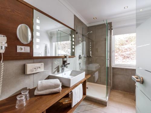 a bathroom with a sink and a shower at Hotel Gasthof Blaue Quelle in Erl