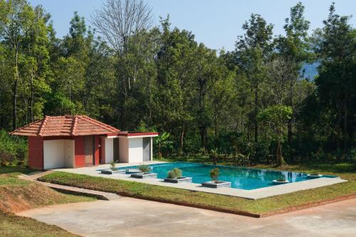 une maison avec une piscine dans une cour dans l'établissement Agraharam Resorts, à Thirunelli