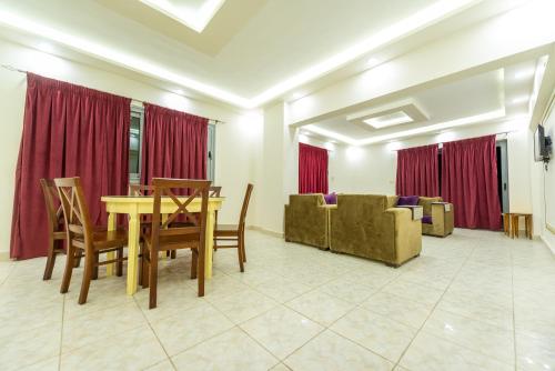 a dining room with a table and chairs and a couch at ZAFERO POREFAG- Families only in Alexandria