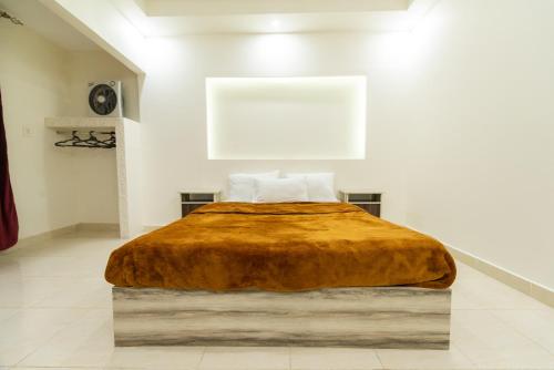 a bed in a white room with a brown blanket at ZAFERO POREFAG- Families only in Alexandria