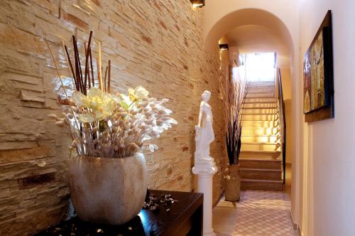 a vase with flowers on a table in a hallway at Hotel Casa Di Meglio in Ischia