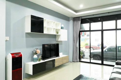 a living room with a flat screen tv on a wall at Khoksametchun Hostel Plus in Hat Yai