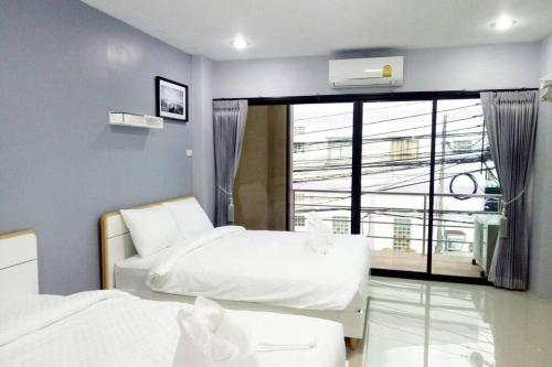 a bedroom with two beds and a large window at Khoksametchun Hostel Plus in Hat Yai