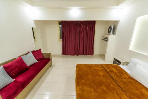 a living room with a couch and a red curtain at ZAFERO POREFAG- Families only in Alexandria