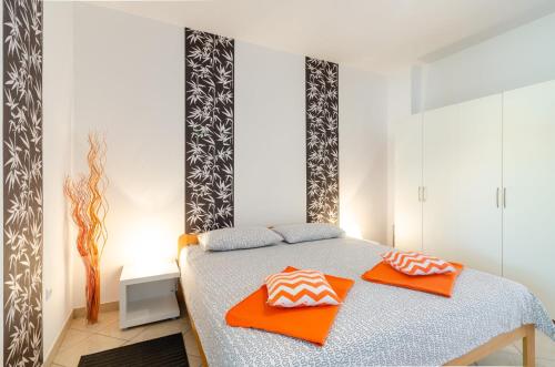 - une chambre dotée d'un lit avec des oreillers orange dans l'établissement Ananas Apartments, à Crikvenica