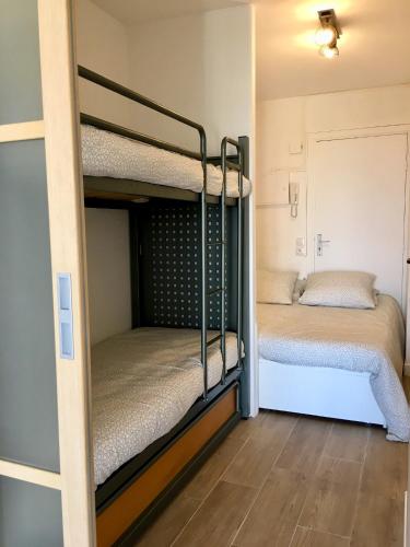 Cette petite chambre comprend 2 lits superposés et du parquet. dans l'établissement STUDIO BANDOL 2 Etoiles Climatisé, à Bandol