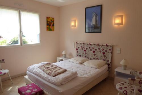 une chambre avec un lit et deux fenêtres dans l'établissement REF 064 Grande maison de famille pour huit personnes Kerjouanno Tumiac ARZON, à Arzon