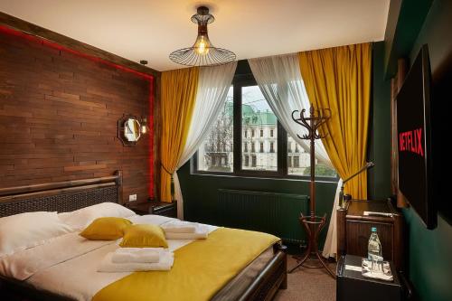 a bedroom with a bed with towels and a window at Piata Unirii Central Apartments in Iaşi