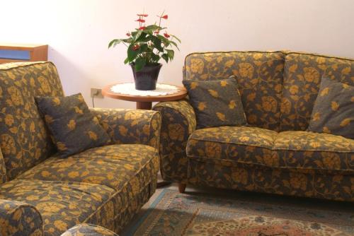 een kamer met twee stoelen en een tafel met een plant bij Hotel Alla Dolina in Sistiana