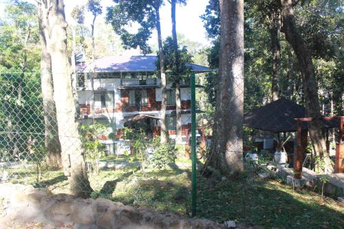 a house in the woods with a fence and trees at VANYA by Citrine in Nelliyampathy