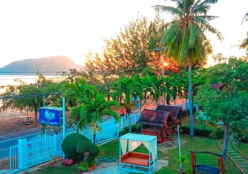 uitzicht op een resort met palmbomen en stoelen bij Baan Golden Pool Villa in Sam Roi Yot