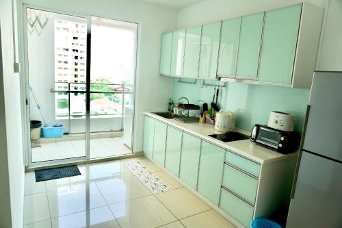 a kitchen with white cabinets and a large window at Gurney Drive Mansion One Serviced Apartment in George Town