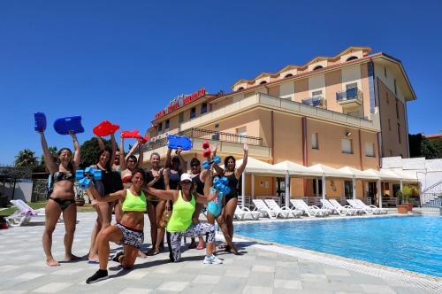 a group of women in bikinis posing by a pool at Grand Hotel Paradiso in Catanzaro Lido
