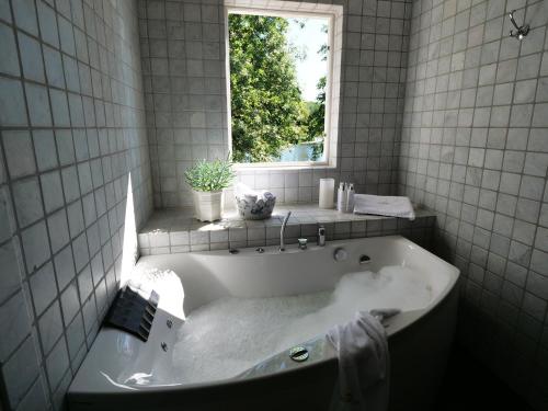 a bath tub in a bathroom with a window at Dufweholms Herrgård in Katrineholm