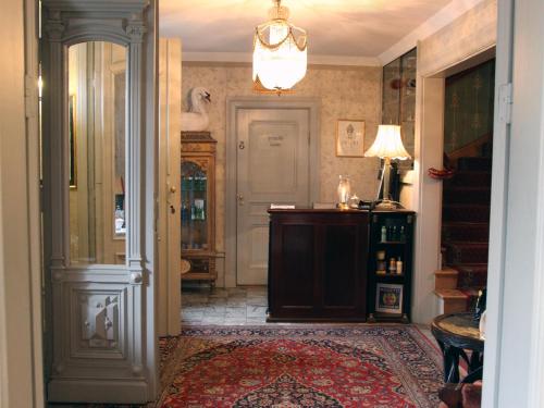 a hallway with a door and a room with a rug at Dufweholms Herrgård in Katrineholm