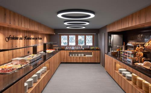 a restaurant with wooden walls and a long aisle at Hotel Alpenhof in Bad Wiessee