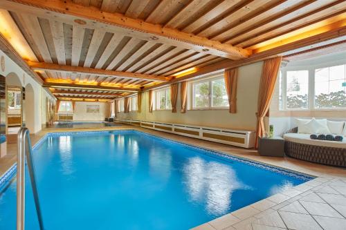 a large swimming pool in a house with a ceiling at Hotel Alpenhof in Bad Wiessee