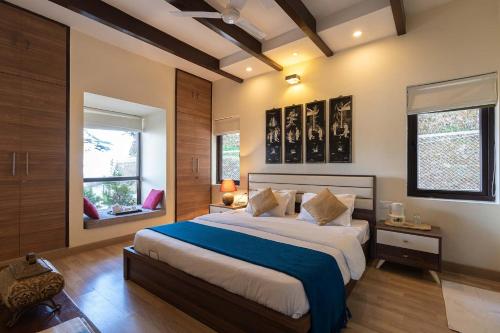 a bedroom with a large bed with a blue blanket at StayVista at Cottage in the Clouds with Heater & Bonfire in Mussoorie