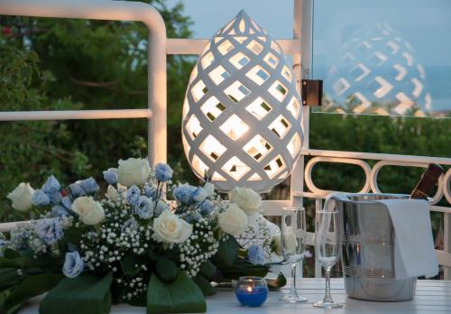 a table with a vase of flowers and a lamp at Grand Hotel Paradiso in Catanzaro Lido